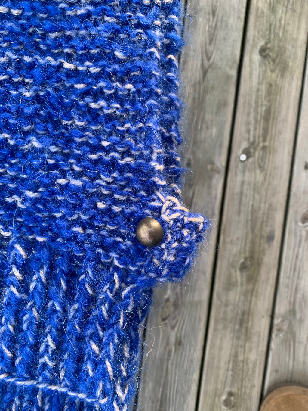 Knappedetalj siden på hals i blått og beige