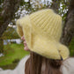 Håndstrikket solgul hatt i mohair og ull med bred oppbrett og gullknapp – Anastasias Yellow fra CosyMonday
