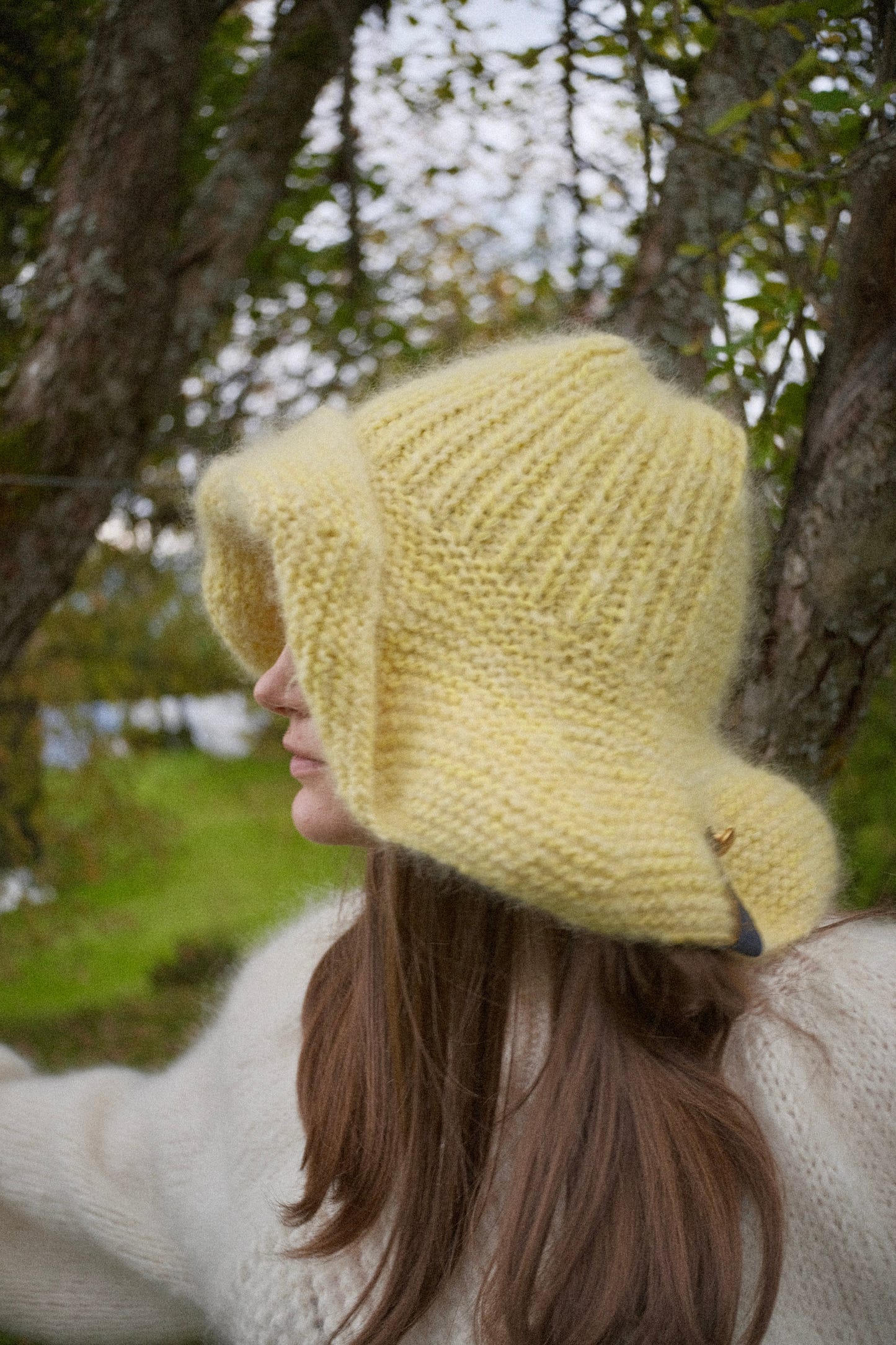 Håndstrikket solgul hatt i mohair og ull med bred oppbrett og gullknapp – Anastasias Yellow fra CosyMonday